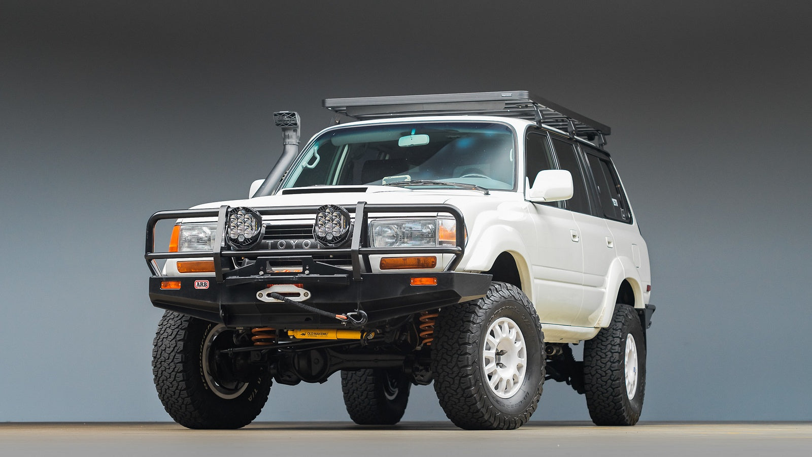 White Toyota 80 Series Land Cruiser offroad touring build exterior front 3/4 hero, white Braid wheels, ARB winch bumper, OME suspension, Ironman 4x4 snorkel
