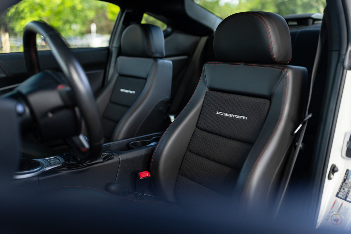 White Toyota GT86 interior looking at the driver seat, a scheel-mann black sportline with round headrest and red accent stitching