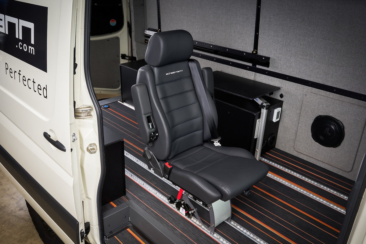 scheel-mann seat with integrated seatbelt in black leather, mounted on a Smartfloor rail system inside a white van and viewed through the open side door