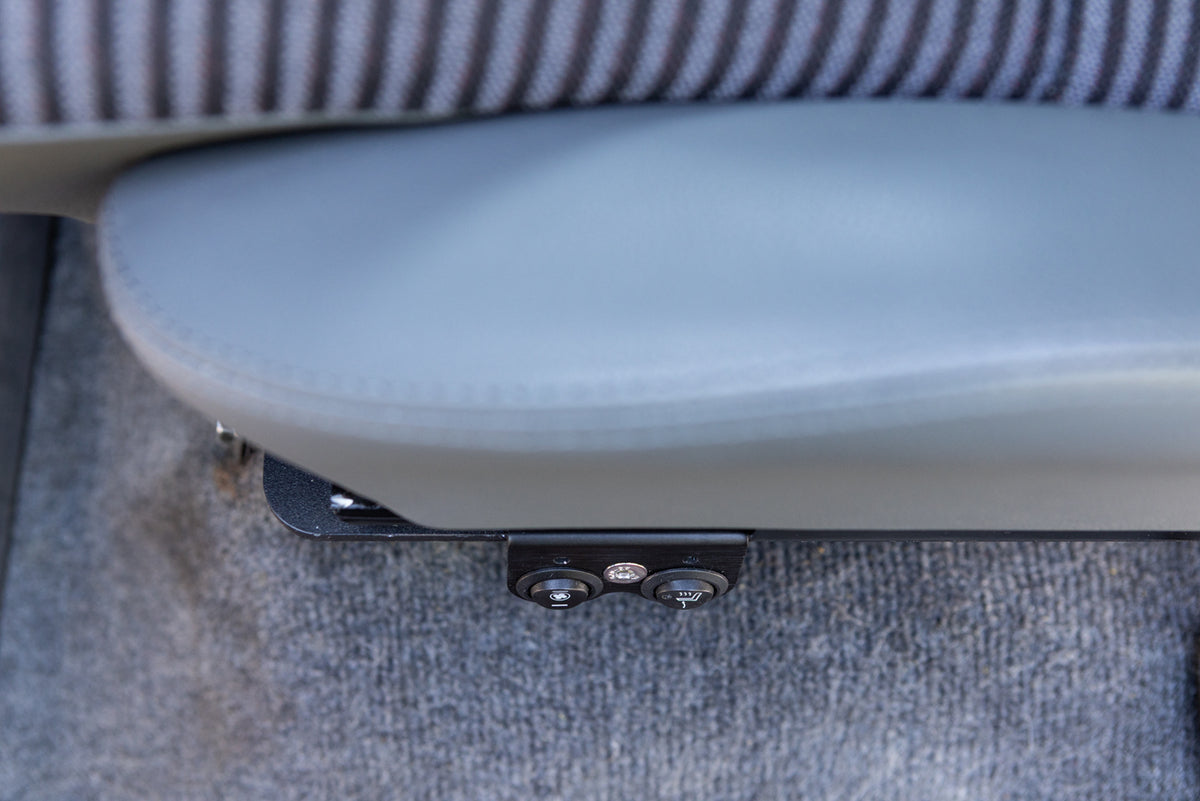 Dual switch mount installed on a driver seat mounted on the left side of the seat bracket, showing bottom cushion and left bolster in gray looking top down