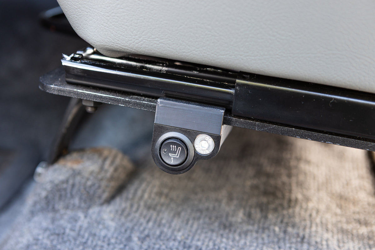 Single switch mount installed on a driver seat mounted on the left side of the seat bracket, detail close up